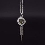 view of the back design on the back of a round labradorite pendant necklace in sterling silver, which has a chain embellishment on the bottom