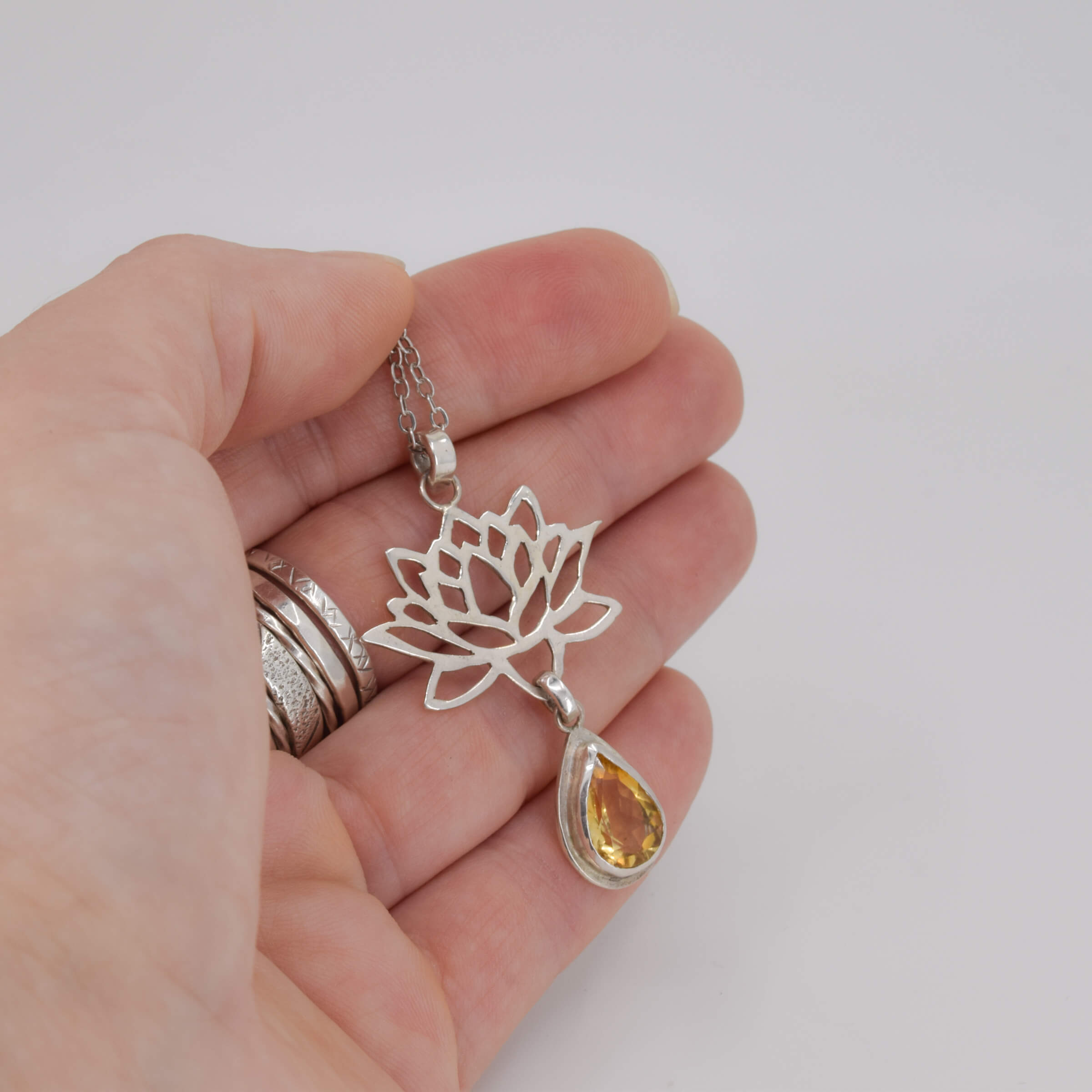 Sterling Silver Lotus Flower Pendant with Citrine Gemstone held in hand for scale