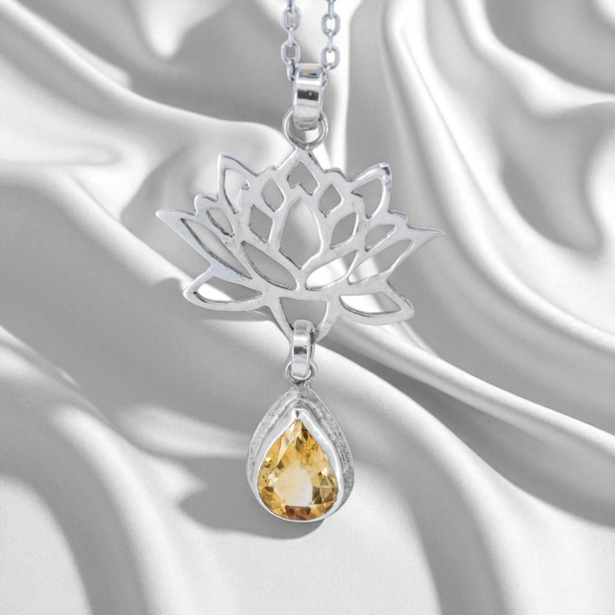 Sterling Silver Lotus Flower Pendant with Citrine Gemstone on a satin background