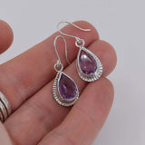 Sterling silver amethyst drop earrings shown in hand for scale