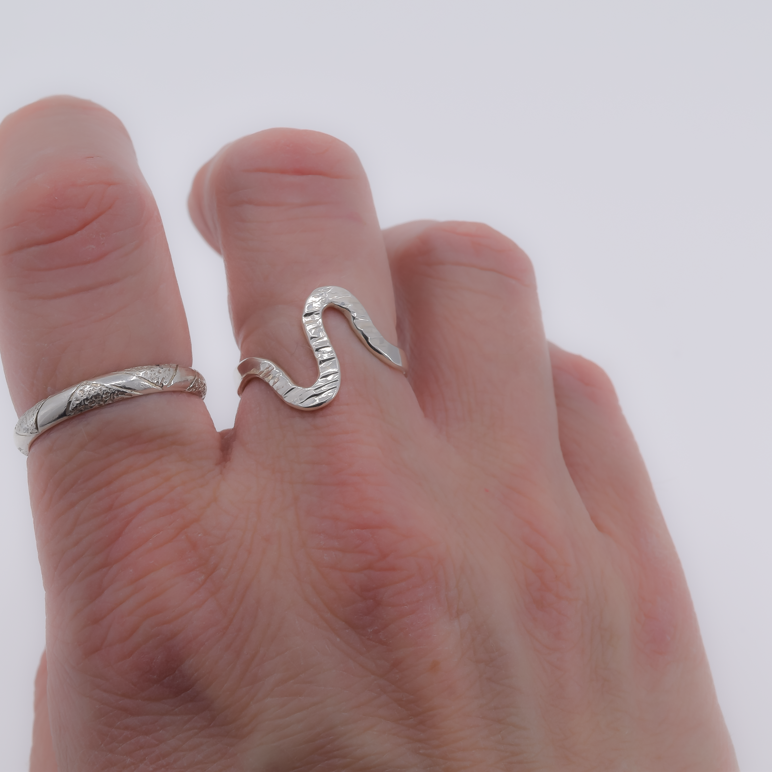 the wave sterling silver ring worn on a finger