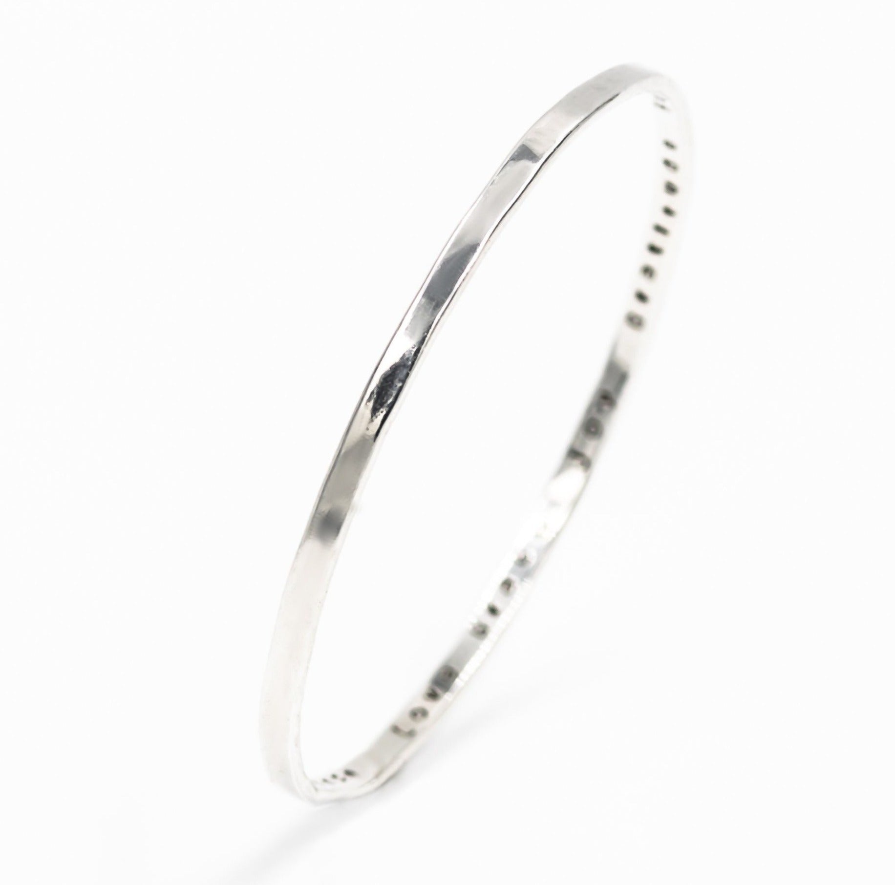 sterling silver bangle bracelet with the words "joy", "love", "patience", "grace", "joy", "faith" stamped on the inside. 
